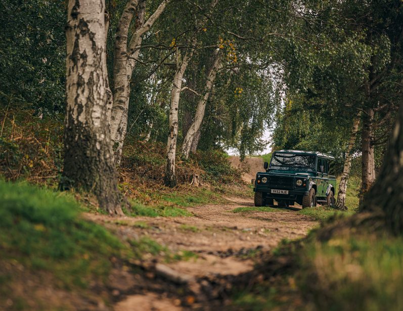 STAUNCH Land Rover Defender Driving a Woodland Track